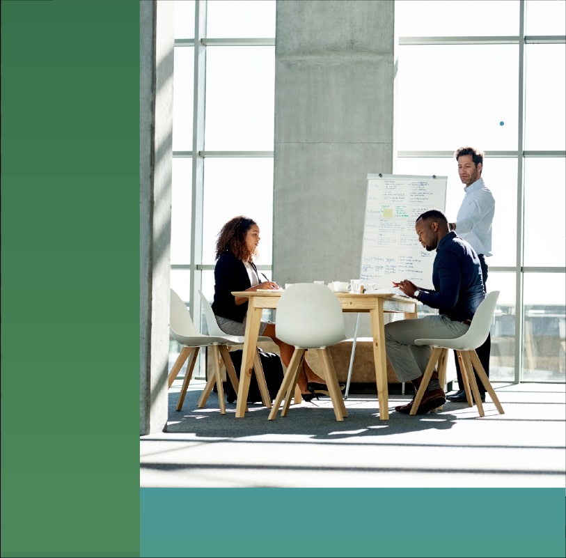 A small team discuss a project during a meeting in an open office environment.