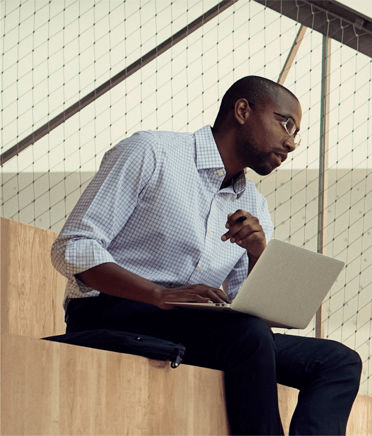 photo of two coworkers having a conversation on bleachers inside of an office presentation room.